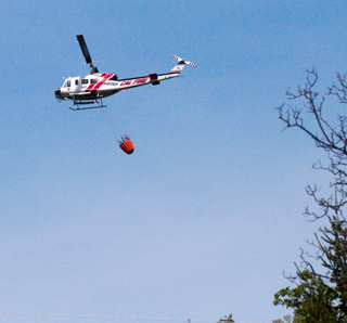 3 April
                    2013 Cal Fire Huey with water bucket just filled at
                    Lake Mendocino